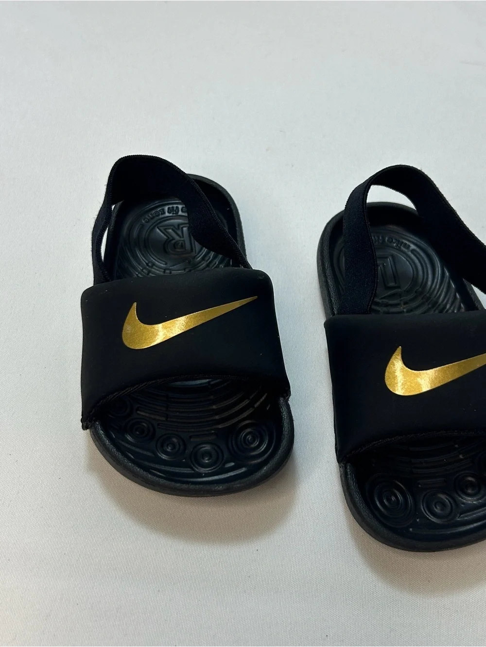 Nike Kids Black Slides with Gold Swoosh and Elastic Heel